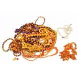 A large quantity of vintage and more modern graduated simulated amber bead necklaces with a rough