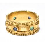 A yellow metal broad ring set with emerald sapphires and rubies, stamped K22, size O 1/2, approx 9.