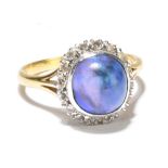 An 18ct yellow gold platinum mounted black opal and diamond set ring, the domed opal cabochon set