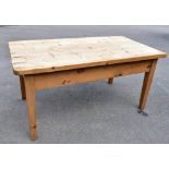 A French style pine farmhouse kitchen table, with rounded rectangular top and a frieze drawer, on