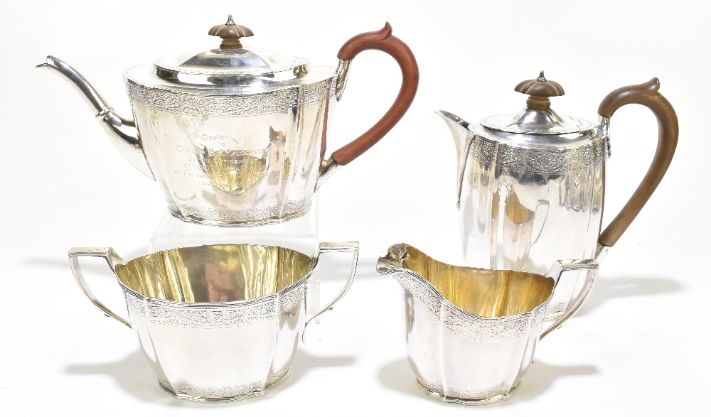 A George V hallmarked silver four piece tea set with band of engraved detail to both upper and lower