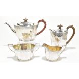 A George V hallmarked silver four piece tea set with band of engraved detail to both upper and lower