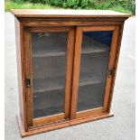 An Edwardian oak bookcase, with two glazed doors enclosing adjustable shelf, on plinth base,