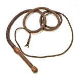 A vintage brown or tan leather long whip with plaited shaft and swiveling grip.Additional