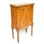 A Victorian faux grainwood pine cupboard, with two panelled doors enclosing shelves, on turned legs,