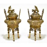 A pair of Chinese bronze censers and covers, of octagonal form with temple dog finials and high twin