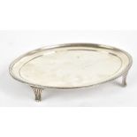 CRISPIN FULLER; a George III hallmarked silver oval teapot stand with reeded rim on four shaped