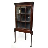 A George III mahogany flat fronted glazed hanging corner cupboard mounted on an associated stand