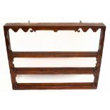 A stained pine hanging plate rack with open shelves and pierced serpentine side panels, height 95.