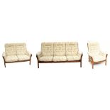 ERCOL; a dark elm three piece Saville suite, comprising a three seater sofa, two seater sofa and
