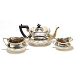 ARNOLD & LEWIS; an Edward VII hallmarked silver three piece tea set with gadrooned detail, London