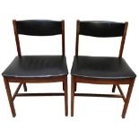 A set of six mid-century teak frame dining chairs, with black vinyl backs and seats, raised on block