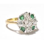 An 18ct yellow gold diamond and emerald cluster ring set with old cut diamonds in a stepped setting,