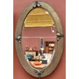 An Arts and Crafts style sheet copper plated wall mirror on oval form with central bevelled plate,