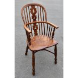 An 18th century elm and ash Windsor elbow chair, with crinoline stretcher, raised on turned column