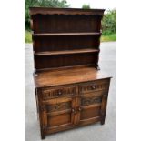 A 1930s oak dresser, the raised back with two shelves over two drawers and 2 cupboard doors on stile