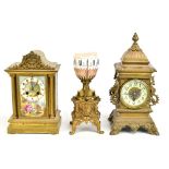 Three late 19th/early 20th century brass mantel clocks, one featuring porcelain panel and signed