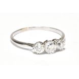 -PLEASE NOTE THE CENTRAL STONE IS 0.25CT NOT 1.25CT: A white metal three stone diamond ring, the