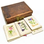 A collection of World War I embroidered silk postcards, the majority blank, housed in a small