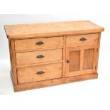 An old pine dresser base with arrangement of four drawers and a cupboard door enclosing single