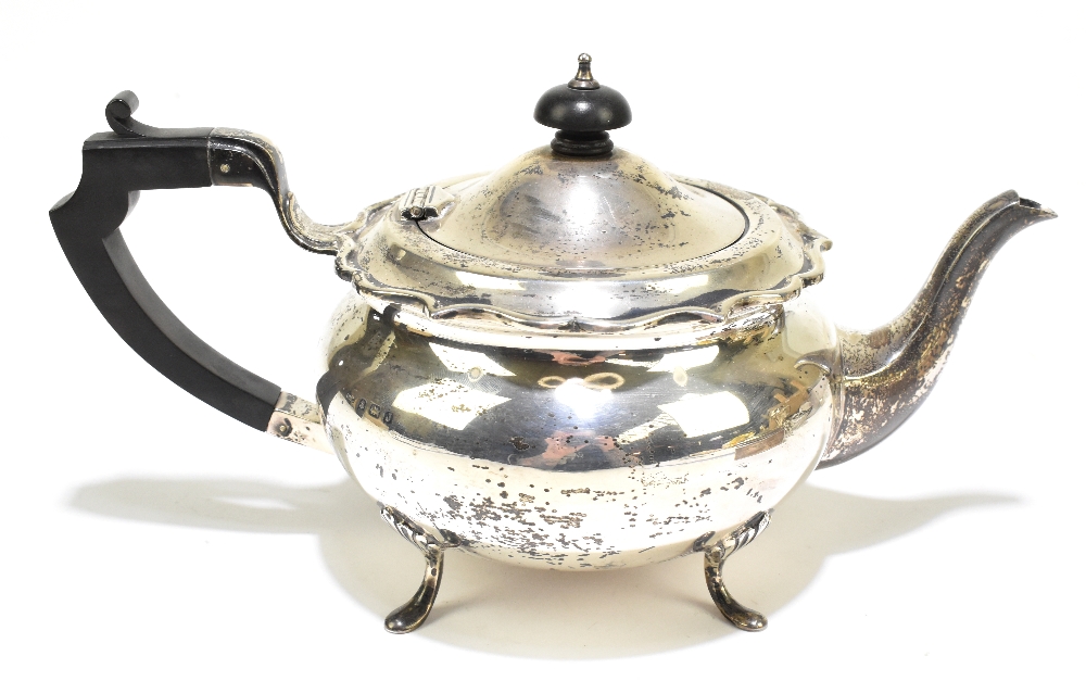 G BRYAN & CO; a George V hallmarked silver teapot of bulbous form with cast scrolling rim,