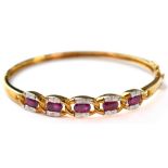 A 9ct gold diamond and ruby hinged bangle,