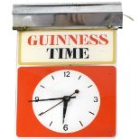 A vintage Guinness Time illuminated suspended clock with white dial within a red block,