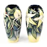 MOORCROFT; two baluster vases, one midnight blue and cream drip glaze with tube lined decoration,