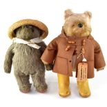 A Paddington Bear with brown overcoat and yellow wellingtons,