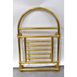 A contemporary brass dome-topped wall mounted heated towel rail with arched top above five-division