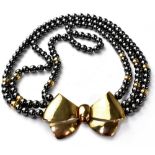 A Boodle and Dunthorne three-string gold bow necklace,