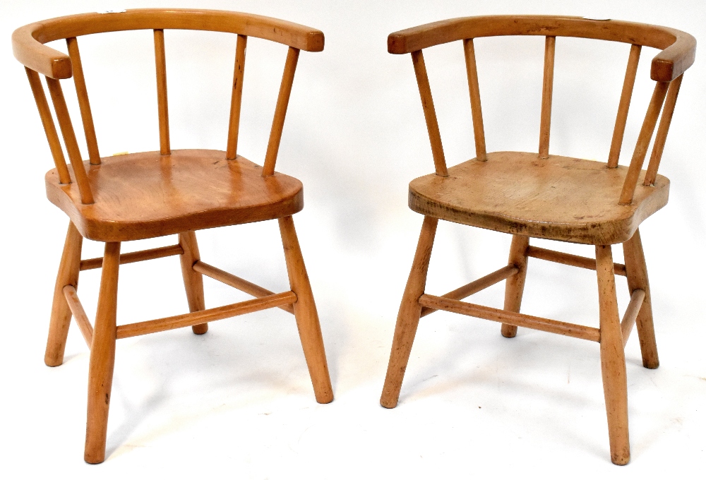 Two children's Windsor-style chairs of matching design, with solid saddle seats, curved back,