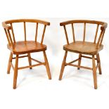 Two children's Windsor-style chairs of matching design, with solid saddle seats, curved back,