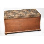 A mahogany ottoman with upholstered padded seat lid, raised on squat bun feet, 57 x 105 x 54cm.