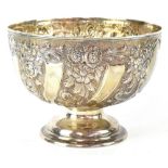 A late Victorian hallmarked silver footed bowl with embossed foliate decoration and opposing vacant