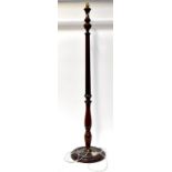 An early/mid-20th century mahogany standard lamp with slender reeded stem,