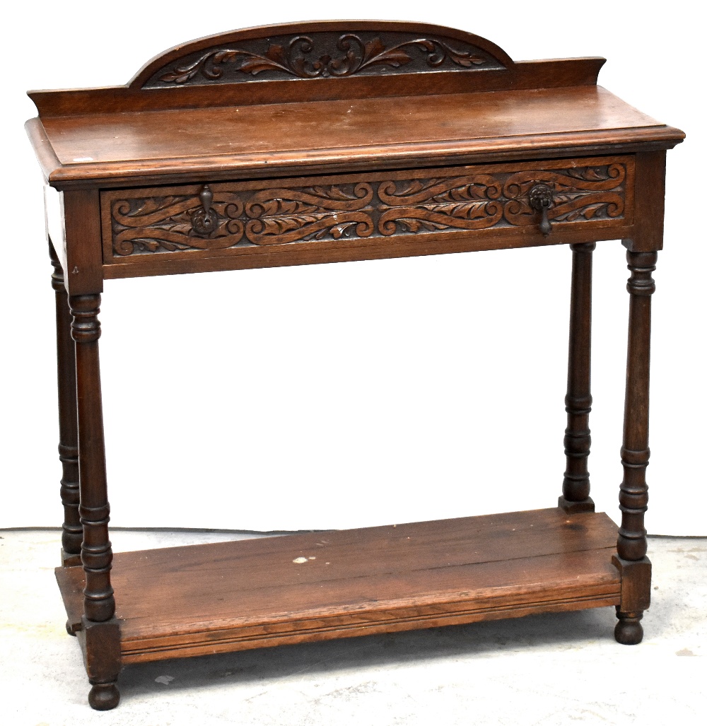 An early 20th century oak side table with single carved drawer,