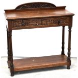 An early 20th century oak side table with single carved drawer,