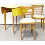 A 1960s yellow Formica covered drop-leaf kitchen table raised on rounded tapering supports and a