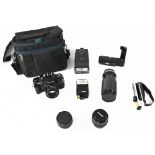 A Chinon Model CG-5 35mm SLR camera with various accessories to include two flash units, handle,