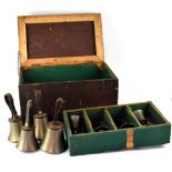 Warners of London; a boxed set of ten brass leather-handled hand bells in fitted baize-lined box,