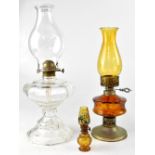 Three varying size oil lamps to include a pressed clear glass example with octagonal oil reservoir