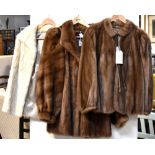 Three vintage c1950s mink jackets comprising an ivory three-quarter length jacket with stand-up