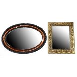 An ebonised and walnut framed oval wall mirror with bevelled plate,