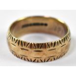 A 9ct gold wedding band with engraved decoration, stamped 375, approx 3.9g.