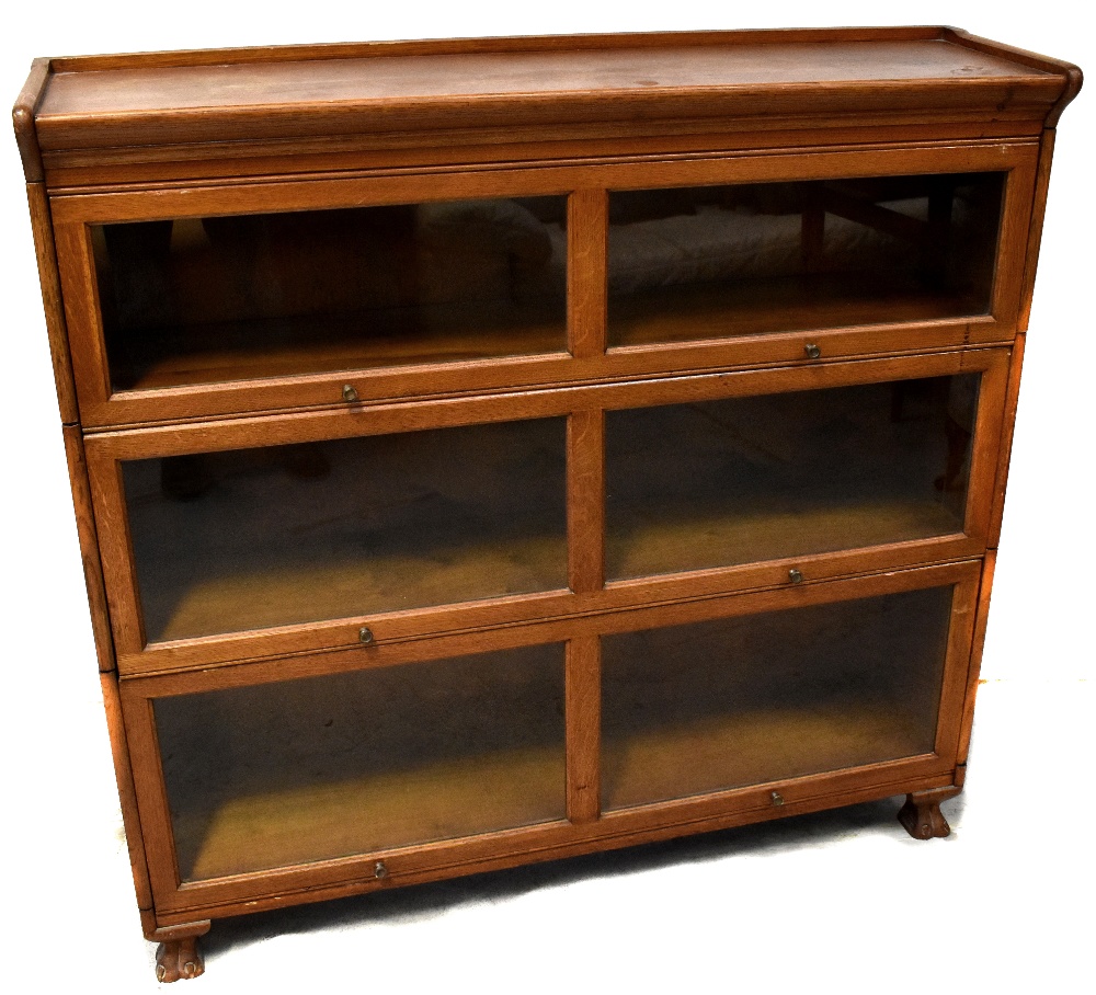 A Gunn oak three-section graduated stacking bookcase with glazed up-and-over doors,