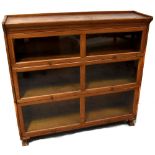 A Gunn oak three-section graduated stacking bookcase with glazed up-and-over doors,