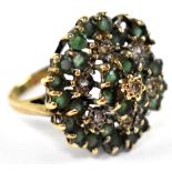 A 9ct gold ring in the form of a flower head set with seven white stones in a surround of green