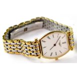 Longines; a ladies' bi-metal tonneau-shaped wristwatch, the white dial set with Roman numerals,