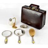 A hallmarked silver filled dressing table hand mirror with repoussé decoration of scrolls, shields,